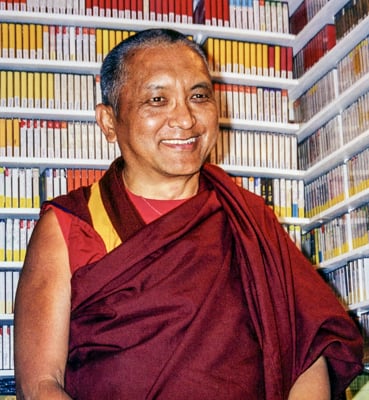 Lama Zopa Rinpoche standing before the Archive tape collection, Brookline, MA 1998.