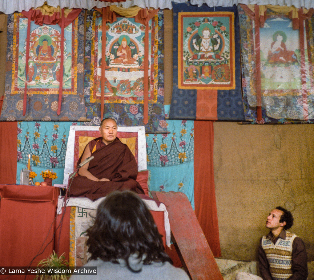 (10237_ng-3.JPG) Lama Yeshe giving final teaching at Sixteenth Kopan course, Kopan Monastery, Nepal, 1983. Karuna Cayton at the foot of the teaching throne. Photo by Wendy Finster.
