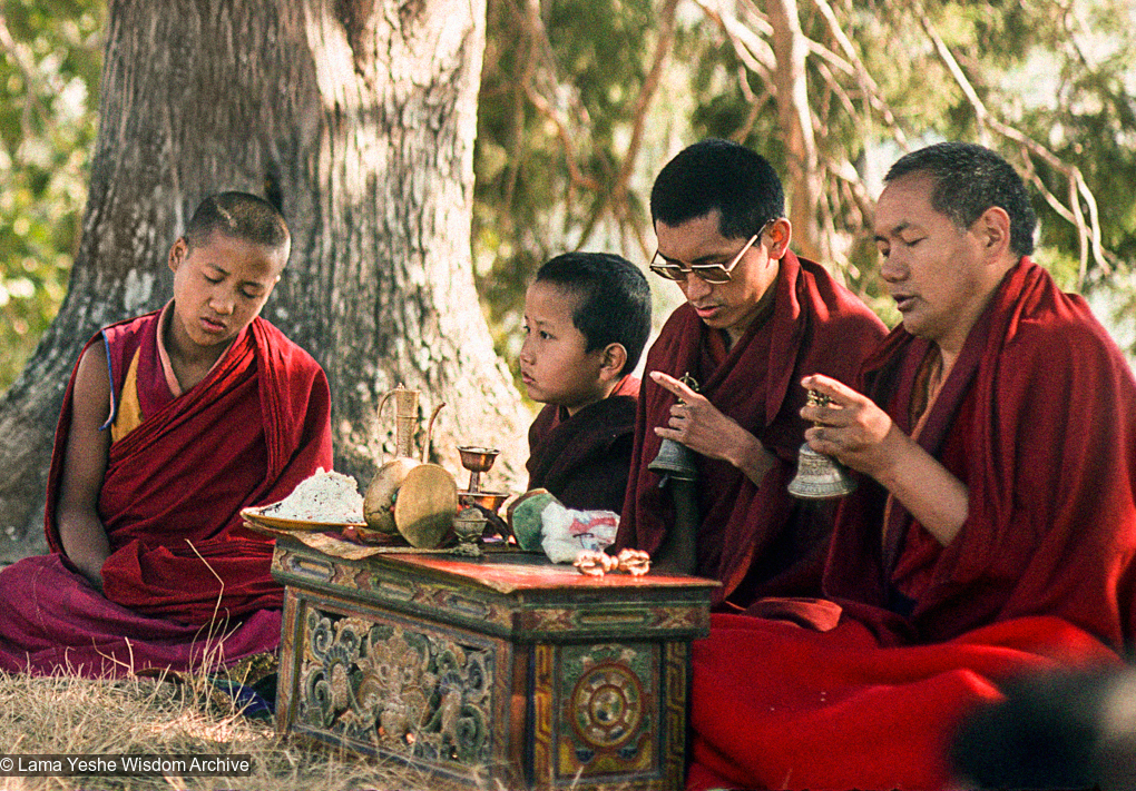 (12736_sl-2.psd) Lama Yeshe and Lama Zopa Rinpoche doing puja (spiritual practice) with Tenzin Norbu under the tree, Kopan Monastery, Nepal, 1976. Photo by Jon Landaw.