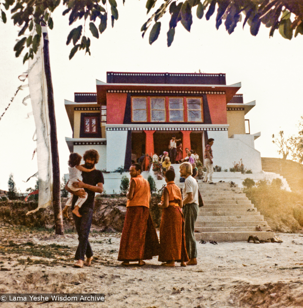 (13288_pr-2.psd) Lama Yeshe at entrance to Kopan with Sister Max Mathews during Fourth Meditation Course, 1973. On the left is Bill Searle holding his son, Adam. Photo by Christine Lopez.