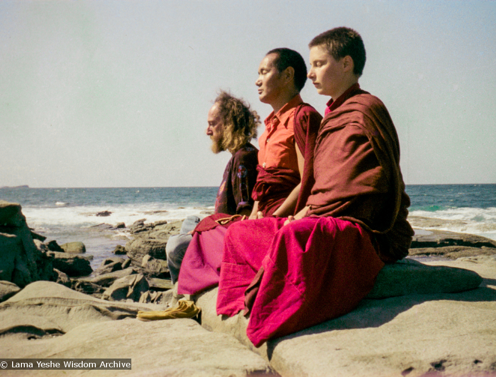 (15851_ng.tif) Lama Yeshe with Yeshe Khadro and Chamba Lane meditating by the ocean, Maroochydore, Australia, 1974. The lamas took a day off during the Diamond Valley course to go to the beach in Tom Vichta&#039;s van. Everyone got out to enjoy the view from the cliffs, but Lama Yeshe ran straight down to the water&#039;s edge, hitched up his robes, and waded in, splashing about with delight.