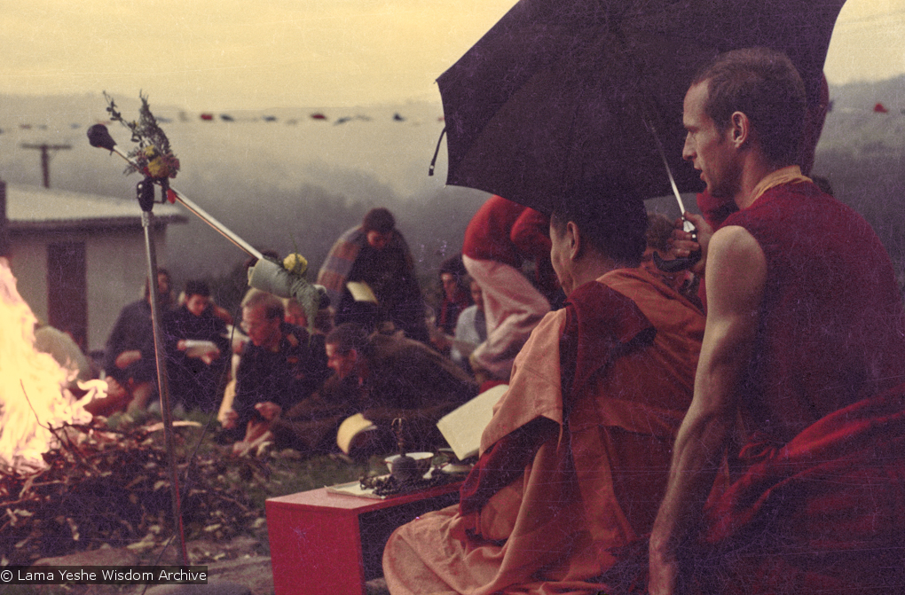 (16052_ng-2.psd) Lama Yeshe doing the Fire Puja (with Jhampa Zangpo (Mark Shaneman) holding umbrella) at Chenrezig Institute, Australia, 1976.