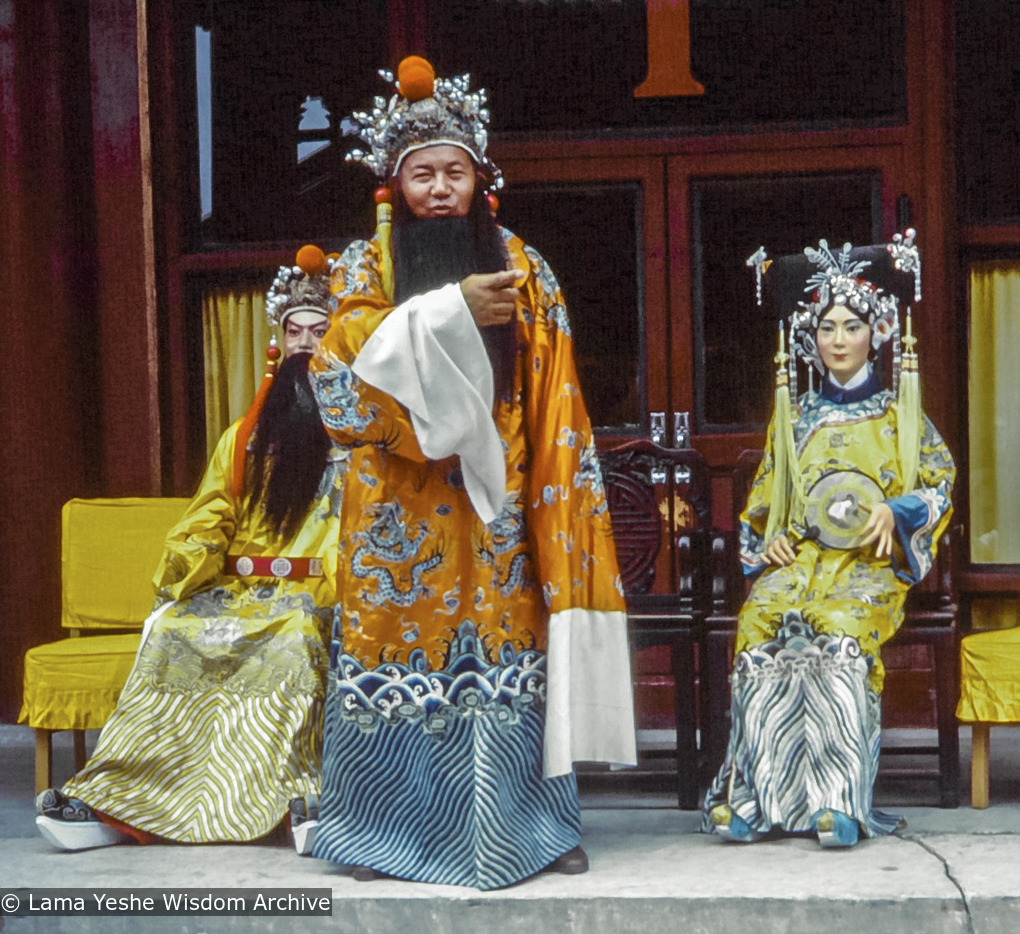 Lama Yeshe in China, 1982.  Marcel Bertels: “One day we came across a photographer’s stall with a painted set. Lama put on an embroidered Chinese robe and a beard and had his photo taken there. He also did a little dance on the set for Max and me.&quot;