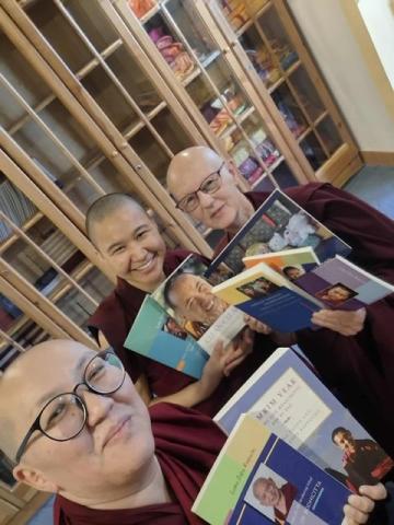 Ani Gyalmo and two fellow nuns at FPMT Mongolia celebrate the arrival of their new LYWA books.