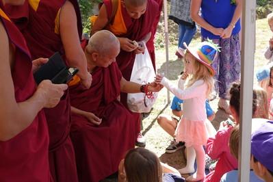 Lama Zopa Rinpoche gives a toy koala to a child at Chenrezig Institute, Australia, Sept. 2014. Photo: Ven. Roger Kunsang.