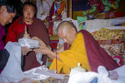 Lama Zopa Rinpoche with a mandala offering, 1990. Photo: Merry Colony.