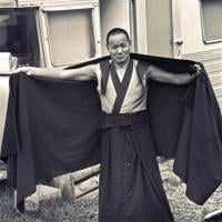 Lama adjusts his robe, 1975