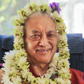 Lama Zopa Rinpoche adorned with flower garlands, 2010